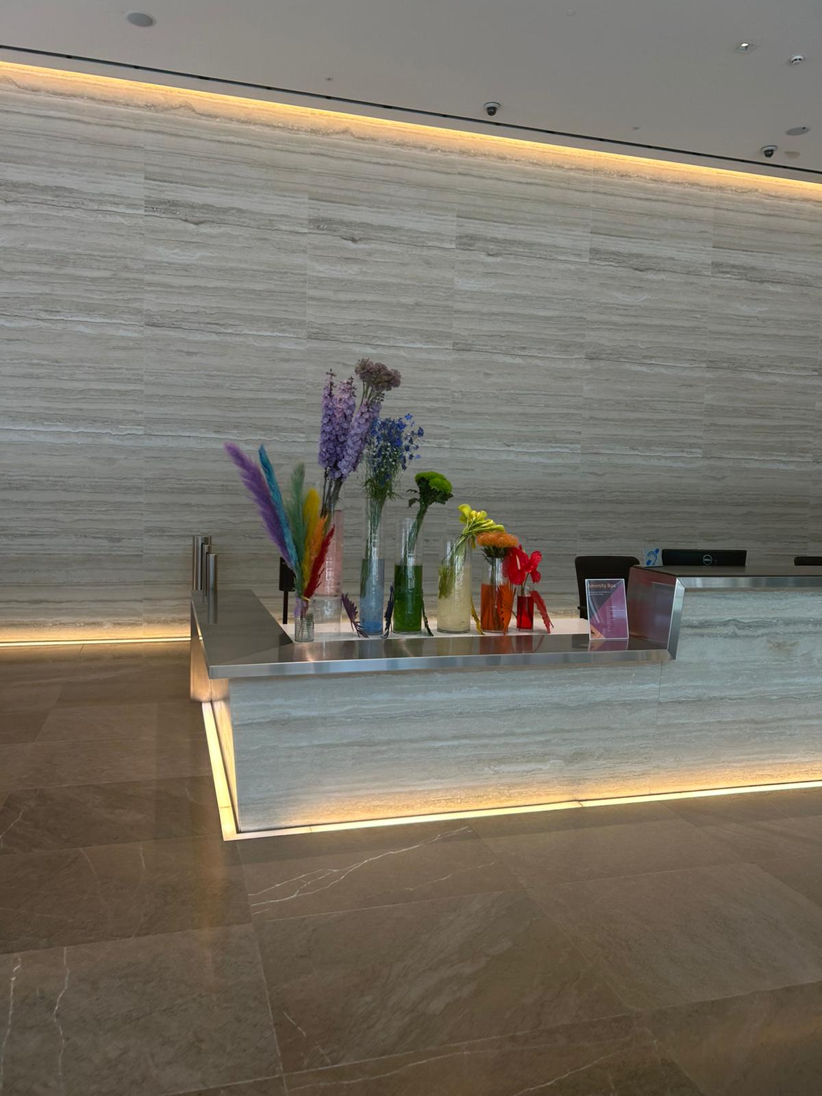 Pride-themed flower display in the reception of a corporate London office, featuring rainbow-coloured floral arrangements for a celebratory nail event