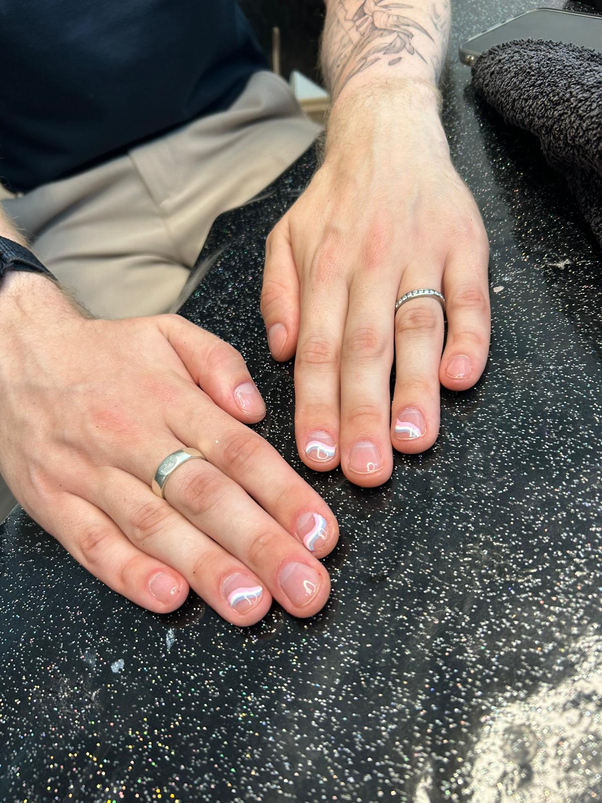 Natural-looking gel manicure on male client during Pride office celebration in London—clean, glossy nails with minimalist finish