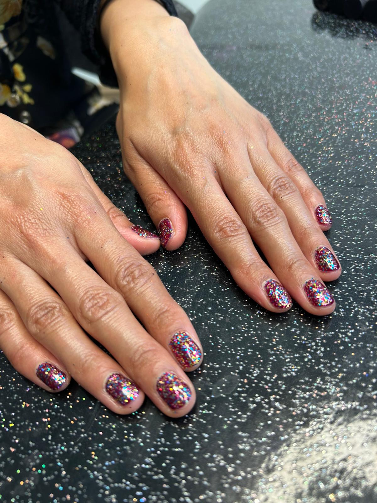Multicolour glitter gel manicure created for Pride celebration in a London fashion office—sparkly statement nails with rainbow shine.
